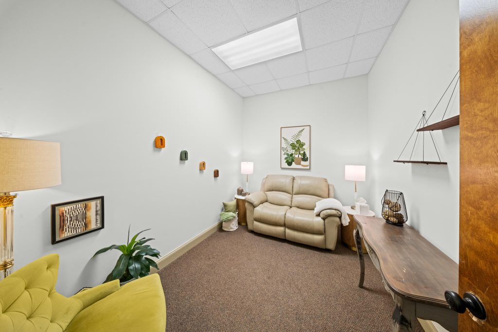 Wide angle view of a bright therapy room with a couch & chair. IHS offers therapy in Alabaster, AL & near Calera. Reach out today to learn more.