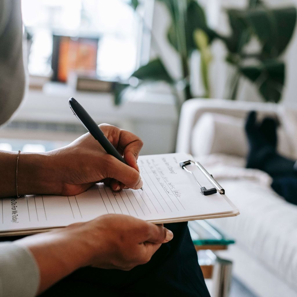 therapist taking notes | lgbtq therapy alabaster | lgbtqia+ therapist alabaster | lgbtq therapist pelham | chronic pain | alabaster, al | pelham, al | gardendale, al A therapist writing notes on a clipboard. Our LGBTQIA+ affirming therapists in Alabama can support you with navigating trauma, ADHD & autism. Start today with IHS!