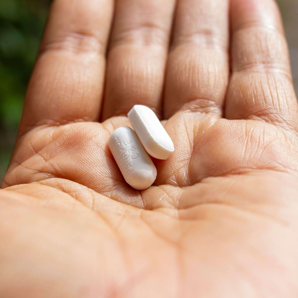 2 white long pills in a person's palm.  IHS offers medication management & therapy in Alabaster, Pelham & Calera. Learn more about our services here.