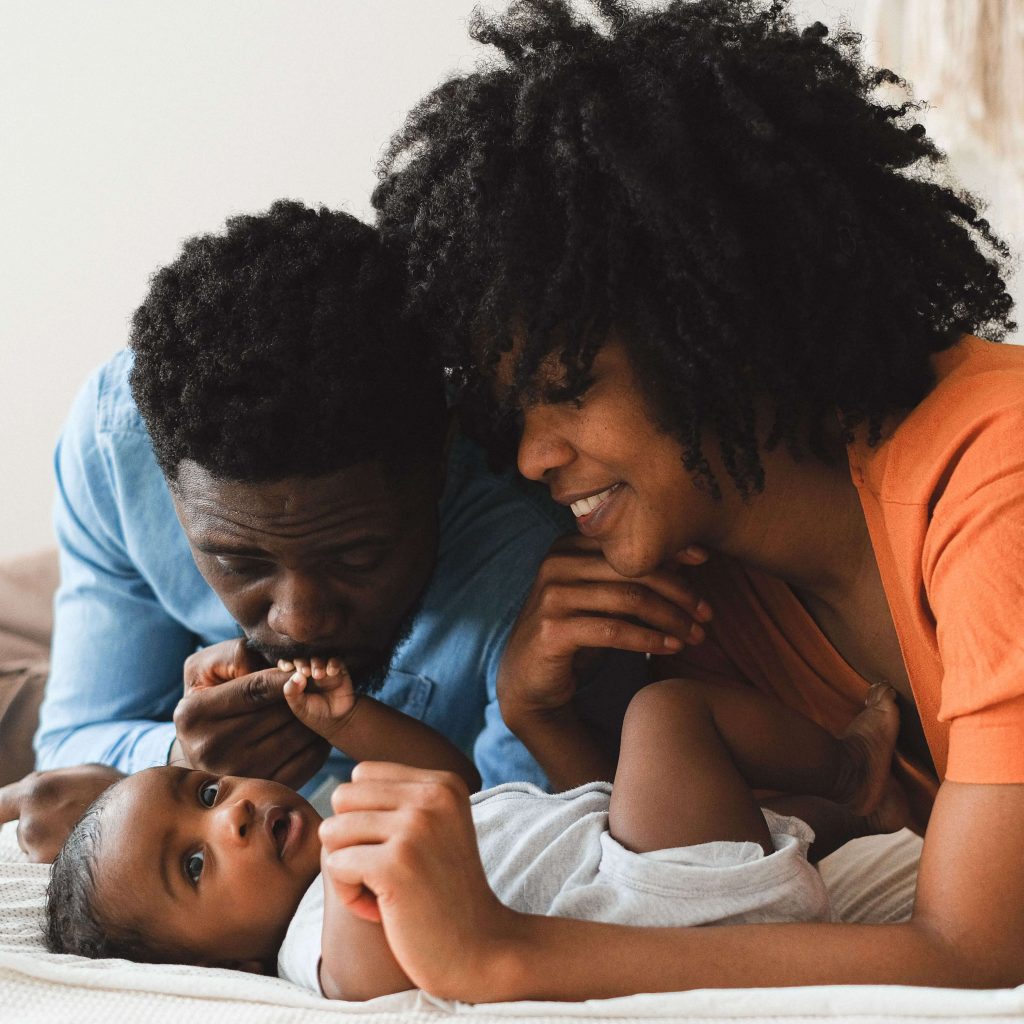 A beautiful black couple loving on their newborn baby. Representing the importance of maternal mental health care. We offer postpartum therapy in Birmingham, AL to support new moms. 